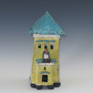 Yellow Clay House With Turquoise Roof With Large Blue Bird Over Door.